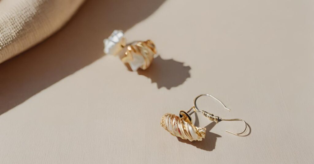 A pair of gold plated earrings on a table.